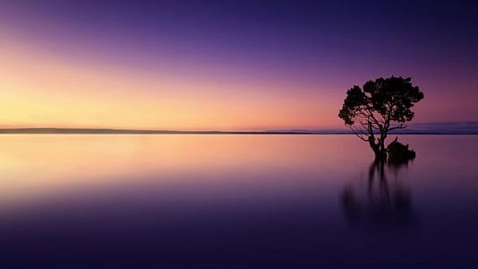 Image of a serene sunset over a calm lake, symbolizing the passage of time